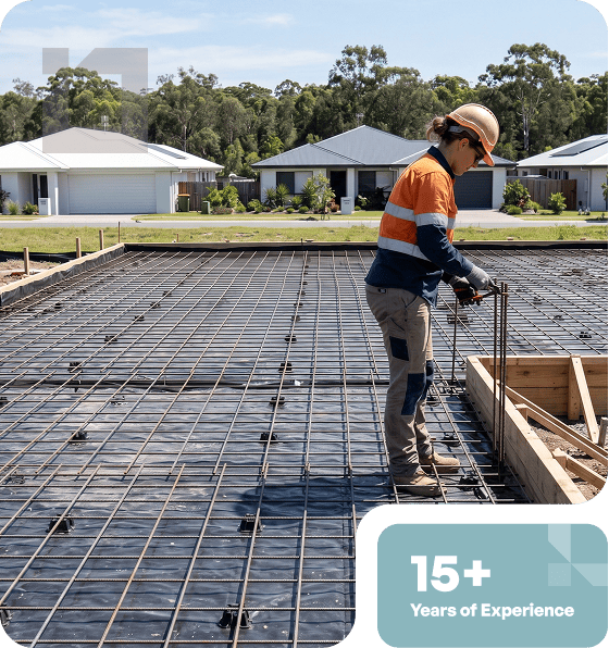 Worker installing rebar for concrete slab at residential site.